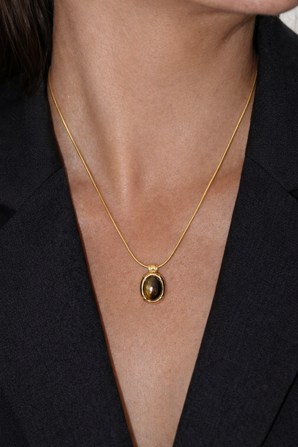 18 ct Gold necklace with a pendant on a person wearing a black top