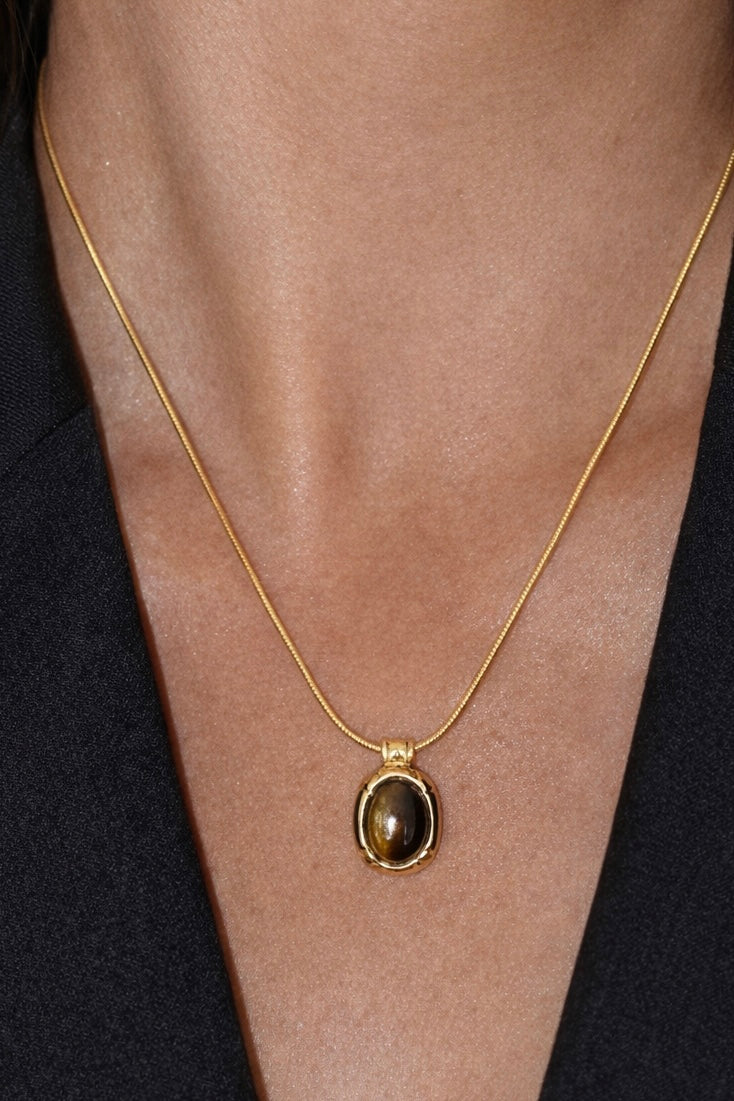 18 ct Gold necklace with a pendant on a person wearing a black garment